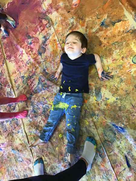 boy in delight laying in paint